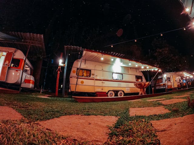 vans with glowing lights at camping area